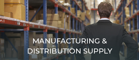 man in suit looking down the aisle of a warehouse